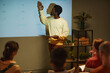 © Seventyfour - Minimal side view portrait of young black man giving presentation by projector screen during business meeting or training session, copy space