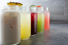 A View Of A Row Of Various Agua Fresca Beverages.
