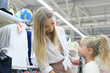 © ribalka yuli - The mother buys things for the girl for school. Young woman chooses a school dress for a girl