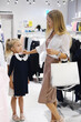 © ribalka yuli - The mother buys things for the girl for school. Young woman chooses a school dress for a girl.