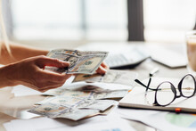Close Up Young Business Woman Using Counting Cash Money One Hundred Dollar Bills, Checking Financial Documents, Siting At Table With Papers And Tax Form, Managing Planning Budget, Accounting Expenses