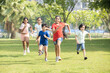 Group of happy playful Indian children running outdoors in summer park. Asian kids Playing in garden enjoy fun activity sport, holidays and vacations ,picnic, camp,  