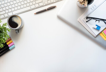 Wall Mural - White office desk with notepad, sticky notes, glasses and coffee cup. Top view with copy space..