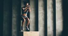 Fitness Woman Jumping On Box While Training At The Gym,girl Doing Cross Fit Exercise. Sports Concept, And Healthy Lifestyle.