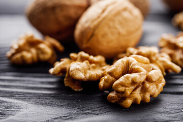 dried walnuts on a black rustic wooden background