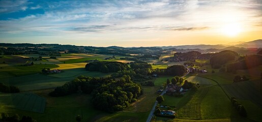 Canvas Print - Aerial view of lush green village in Switzerland during sunset