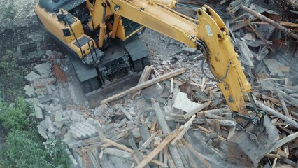 Wall Mural - Demolition of building. Excavator breaks old house, aerial view.