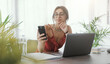 © StockPhotoPro - Young woman sitting at desk and using her smartphone