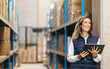 © Jacob Lund - Female warehouse manager smiling while holding a digital tablet