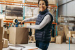 © Jacob Lund - Happy warehouse worker taping a cardboard box with scotch tape