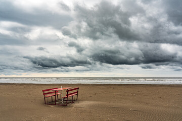 Wall Mural - Lonely bench on the shore of a stormy sea