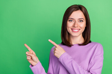 Poster - Closeup photo of young cute smiling woman finger pointing empty space recommend this employer good salary isolated on green color background