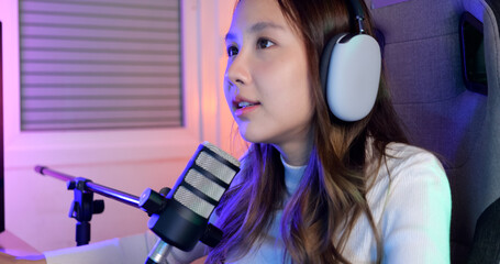 Close up view of young female gamer with long hair playing online game on computer at home, Gamer woman wearing headsets taking on microphone with teammates