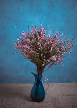 Bouquet of heather in a blue vase. Classic still life.