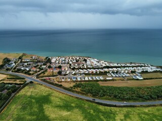 Sticker - View of beautiful small village, green meadows and road on hill near to long coastline with blue sea