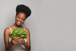 Leinwandbild Motiv Happy black woman with greens on white banner background. Healthy eating concept