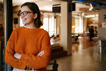 White ginger woman in eyeglasses laughing while working at office