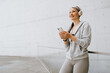 © Drobot Dean - Asian mature woman in headphones using cellphone during workout