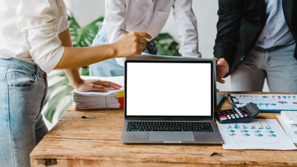 Blank white screen laptop, Close up creative team colleague three business man and women discuss ideas in the boardroom. initiation of a brainstorming session to start an office business.