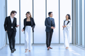 Wall Mural - Four young men and women in Asian suits are meeting at a company Happy and excited about work. The concept is Finance, Marketing, Accounting.