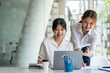 © crizzystudio - Two young female accountants in casual clothes working with laptops and discussing company investment results and profits and annual bonuses, finance ideas, and collaboration.