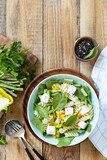 Fototapeta Kuchnia - Cold delicious pasta salad, italian cuisine. Whole wheat fusilli pasta with  feta, green bean and pepper on a wooden background. View from above. Copy space.