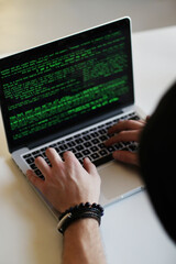 Behind the Screen: A Hacker's World Revealed as He Works on His Computer in a House Near the Window