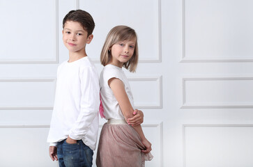 A girl and a boy sit in the studio and pose for a photo