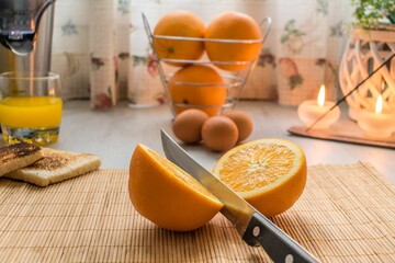 Poster - Half of an orange on a chopping board, ready to make a fresh juice