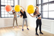 A group of fit young women in Pilates with colorful yoga balls