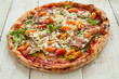 Picture of delicious hot whole pizza with vegetables on a wooden background