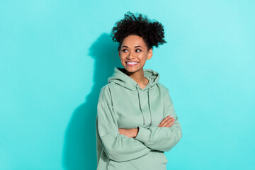 Wall Mural - Photo of minded cheerful girl folded hands look interested empty space isolated on teal color background