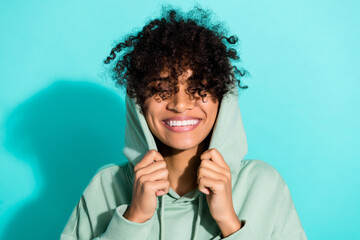 Wall Mural - Photo of satisfied nice person hands put hood head toothy smile hair cover eyes isolated on bright cyan color background