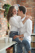 © racool_studio - The woman on the kitchen table hugging her boyfriend’s neck