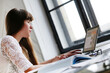 © racool_studio - Beautiful, sweet, young girl with long hair sitting and working on the computer against windowsill.
