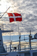 Dannebrog, dänische rot weisse Fahne Flaggge im Wind im Gegenlicht auf Kreuzfahrtschiff.