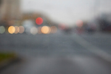 Car window on a day time with bright colorful blurs of a city road in the background.