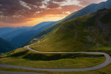 Amazing view of Transfagarasan road in the Carpathian Mountains of Romania under a sunset colorful sky