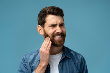 Frustrated Bearded Man Touching Cheek And Wincing In Pain Feeling Terrible Tooth Ache