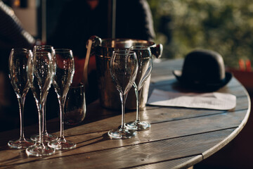 several empty beautiful glass wine glasses stand on the table with glare from the sun.