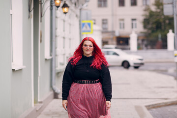 Wall Mural - European plus size woman. Young red pink haired body positive girl walk at city street outdoors