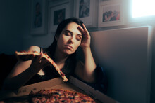 Stressed Tired Woman Having A Slice Of Pizza At Night . Unhappy Tired Depressed Person Binge Eating During Nighttime
