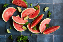 Watermelon Slices With Mint & Lime On Blue Tiles