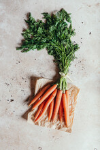 Fresh Bunch Of Carrots On Light Background With Paper Bag