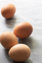 Four Brown Chicken Eggs On A Marble Benchtop.