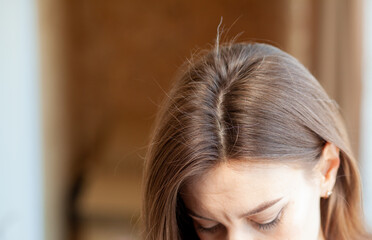 parting of women's hair on the head. hair care and care. closeup of a woman's head with parted gray 