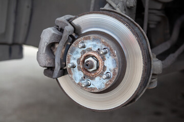 Poster - Disc brake of the vehicle for repair, in process of new tire replacement. Car brake repairing in garage.Suspension of car for maintenance brakes and shock absorber systems. Replacement of brake pads.
