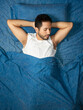 © Narayan - young latin man sleeping blue color bed, rest concept