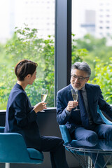 Poster - ロビーでシャンパンを飲みながら談笑するエグゼクティブ男女