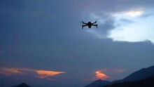 Silhouette of a drone during the sunset or sunrise, unmanned aerial vehicle in the outdoor